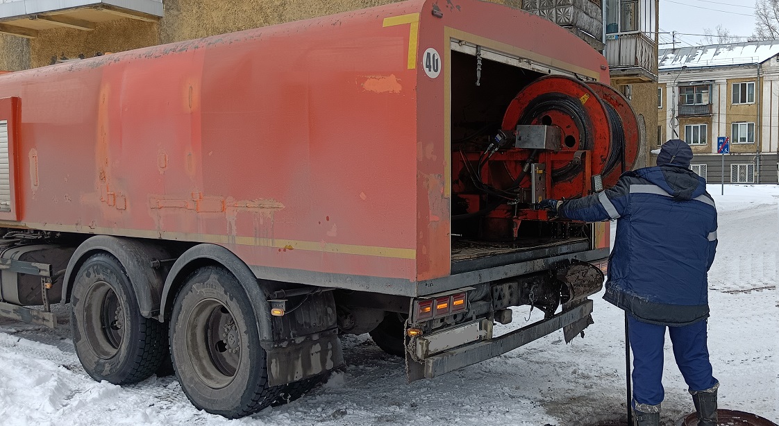 Каналопромывочная машина и работник прочищают засор в канализационной системе в Петропавловске-Камчатском