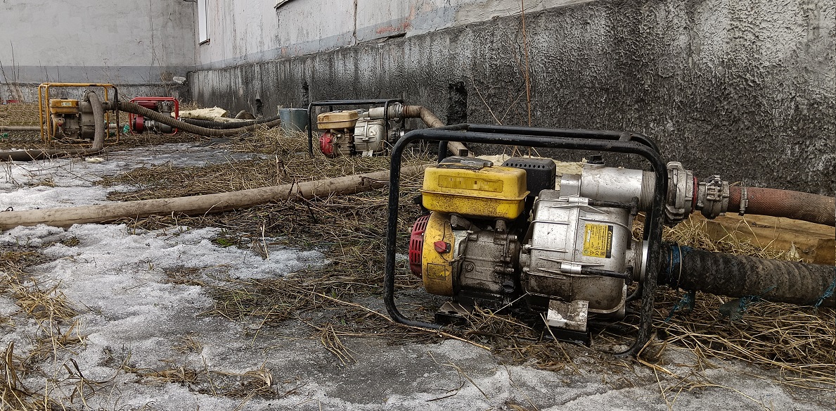 Откачка мотопомпами талой воды из подвала дома в Вилючинске